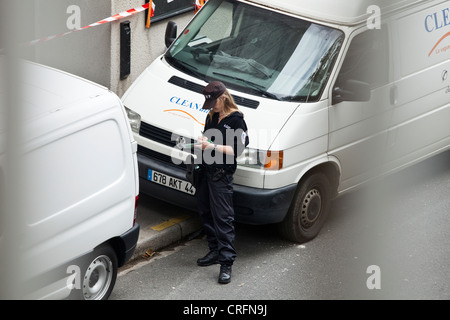 Un vigile o agente de surveillance de la voie publique, emette un biglietto di parcheggio in una strada a Nantes, Francia. Foto Stock