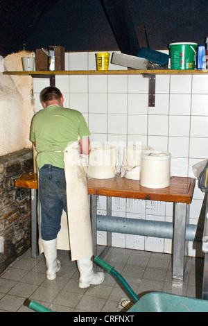 Produzione di formaggio artigianale: decantazione della cagliata e il riempimento di forme con ricotta, Svizzera Vallese, Taeschalp, Zermatt Foto Stock