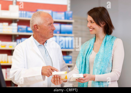 Il farmacista di parlare al paziente in store Foto Stock