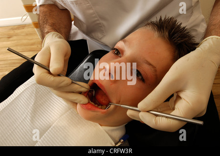 Un giovane ragazzo avente i suoi denti esaminati da un dentista. Foto Stock