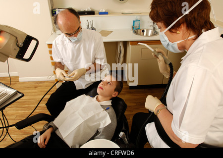 Un giovane ragazzo seduto in poltrona del dentista in attesa di trattamento per iniziare. Foto Stock