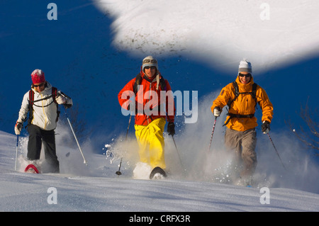 Tre persone con le racchette da neve, passeggiate nella neve profonda, Francia, Alpi Foto Stock
