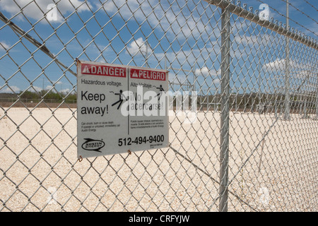 Austin Texas USA, giugno 2012: Segnale di pericolo alta tensione sulla recinzione della catena presso la fattoria di energia solare in Texas in inglese e spagnolo. ©Marjorie Kamys Cotera Foto Stock