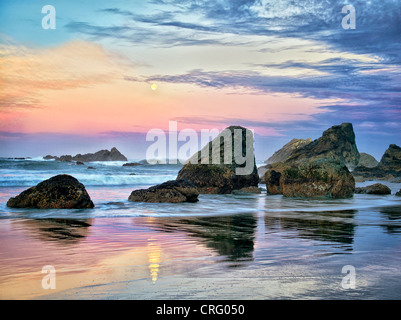 Sunrise e calare della luna piena con la riflessione a Harris Beach State Park, Oregon Foto Stock