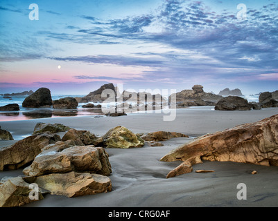 Sunrise e calare della luna piena con la riflessione a Harris Beach State Park, Oregon Foto Stock