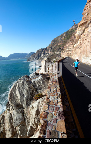 Una donna in corsa lungo il Chapmans Peak Drive vicino a Cape Town, Sud Africa. Foto Stock