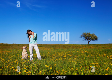 Bella ragazza con il suo cane sul prato Foto Stock