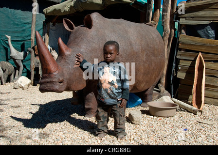 Figure in legno, ragazzo di fronte a rhino, Namibia, Okahandja Foto Stock