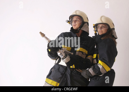 Due vigili del fuoco con noozle Foto Stock