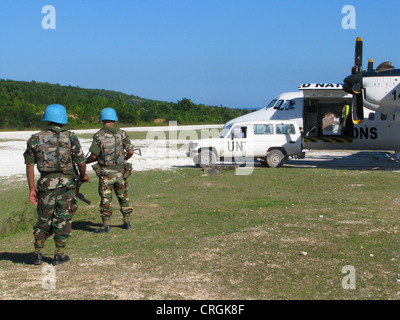 I soldati del 'ONU missione di Stabilizzazione di Haiti" secure aerei ONU con la mitragliatrice e il fucile di assalto accanto alla pista sterrata, Haiti, Grande Anse, Jeremie Foto Stock