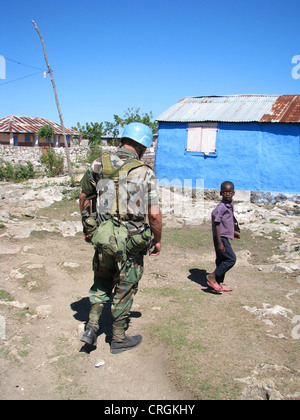 Soldato dell' Organizzazione delle Nazioni Unite la missione di Stabilizzazione di Haiti" di pattuglia incontrando Haitian boy , Haiti, Grande Anse, Jeremie Foto Stock