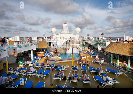 Ponte superiore con sedie di tela e una piscina su di una nave da crociera Foto Stock