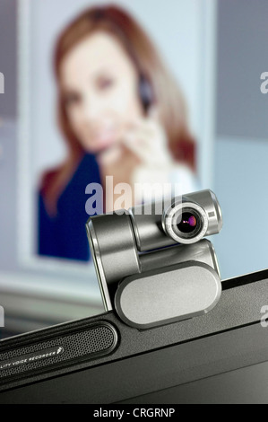 Webcam installata sul monitor del computer, ritratto di una donna in background Foto Stock