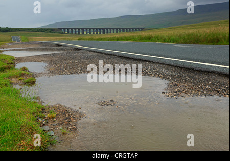 Un giorno di pioggia nel North Yorkshire. Pozzanghere accanto alla B6255 e una vista nebbiosa del viadotto Ribblehead. Foto Stock