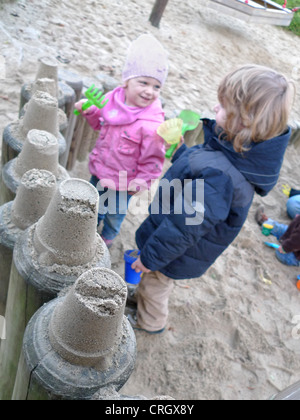 Bambini che giocano in una buca di sabbia, costruire torri di sabbia Foto Stock