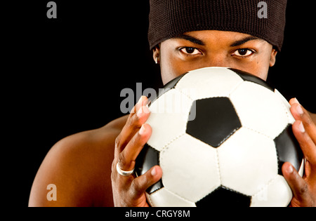 Calciatore maschio con un calcio nelle sue mani Foto Stock