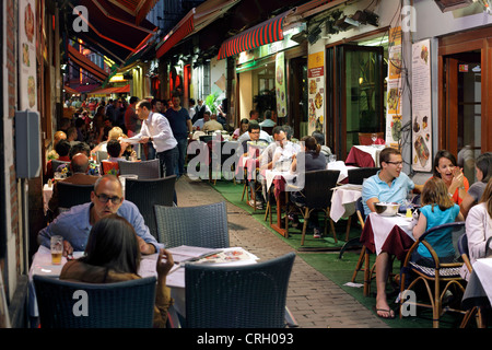 Mangiare fuori in Rue des Bouchers, inferiore della città di Bruxelles, Belgio. (La sera tardi shot - fotografia scattata al buio). Foto Stock