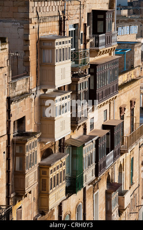 Decorati balconi in legno recintati (gallarija, gallariji) sono una caratteristica tradizionale su molte vecchie case a la Valletta, Malta Foto Stock