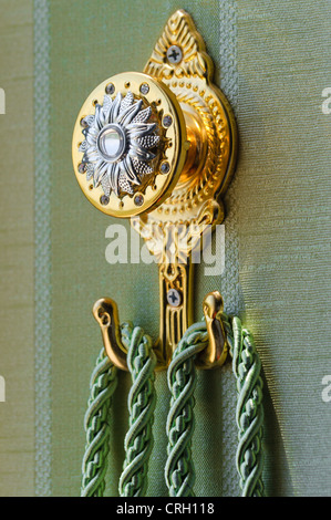 Metallo giallo porta tenda con fiocco corda Foto Stock