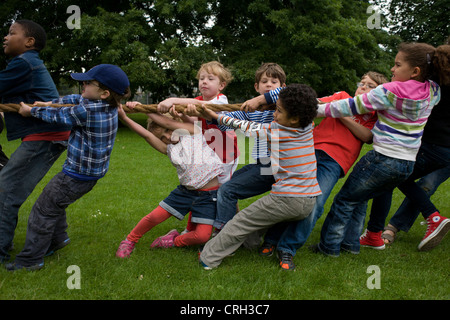 Bambini locali heave-ho su una corda di grandi dimensioni per il migliore dei tre tug o i giochi di guerra durante una comunità park festival. Foto Stock