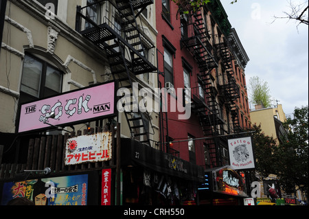 Tenements ornati con 'Sock Man' negozio di abbigliamento, "dipendenza" NYC tattoo studio segni, St Mark, East Village, New York Foto Stock