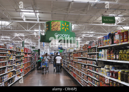 Gente che spinge i carrelli della spesa nell'isola della spesa al Walmart Foto Stock