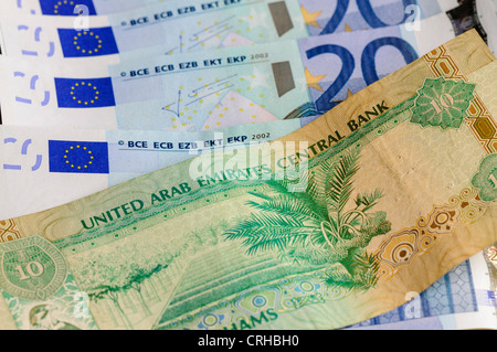 10 UAE Dirhams bank nota contro un numero di banconote in euro Foto Stock