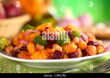 La zucca, barbabietole, broccoli e insalata di ceci guarnito con semi di sesamo con ingredienti nella parte posteriore Foto Stock
