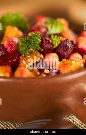 La zucca, barbabietole, broccoli e insalata di ceci guarnito con semi di sesamo nel recipiente rustico Foto Stock