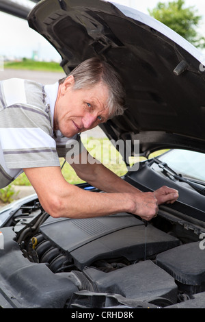 Coppia uomo caucasico un controllo del livello dell'olio sotto il cofano per auto Foto Stock