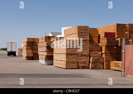 Legname accatastati in un deposito di legname Foto Stock