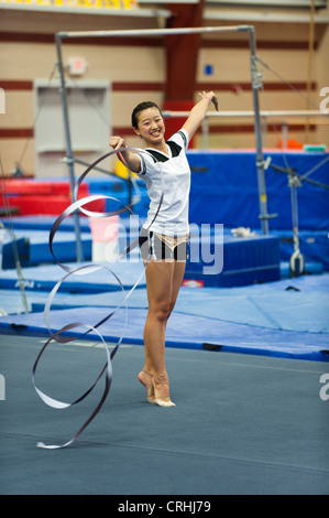 Ragazza adolescente ginnasta praticare ginnastica ritmica, fa roteare il nastro Foto Stock