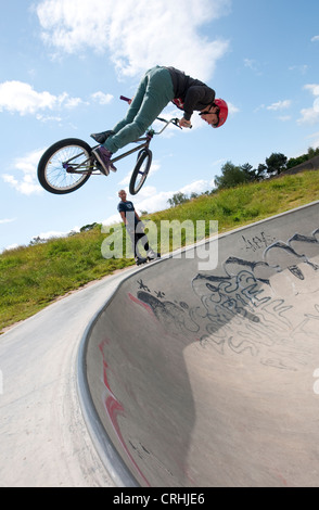 Il pilota di bmx in ambiente urbano skate park bowl, Eaton park, Norwich, Norfolk, Inghilterra Foto Stock