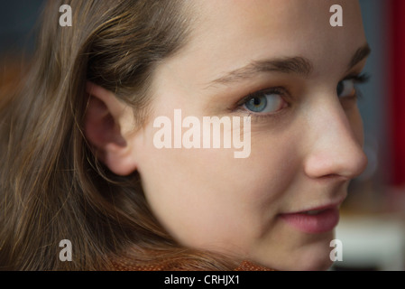 Giovane donna guardando sopra la spalla, ritratto Foto Stock