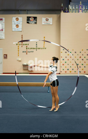 Ragazza adolescente ginnasta praticare ginnastica ritmica, fa roteare il nastro Foto Stock