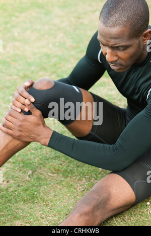 Atleta maschio indossa ortesi per ginocchio Foto Stock