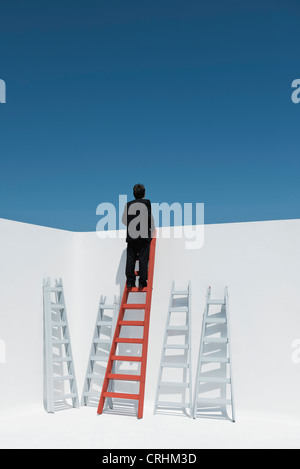 Imprenditore scaletta di arrampicata, vista posteriore Foto Stock