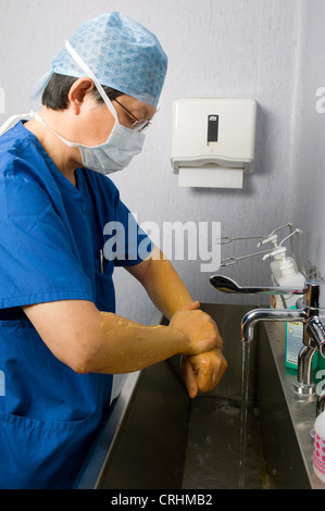 Un medico frega le mani come parte della procedura prima e dopo la chirurgia. Foto Stock