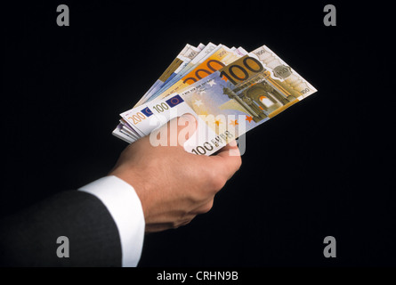 Le fatture in euro nella mano di un uomo vestito Foto Stock