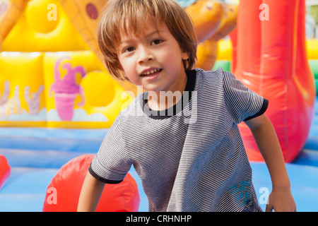 Ragazzo giocando in castello gonfiabile, ritratto Foto Stock