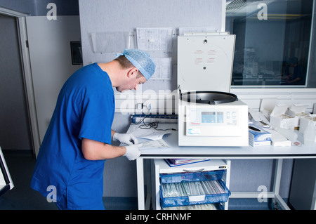 Un medico controlla il paziente lavoro di carta per identificare la fase in cui i campioni sono stati trattati a. Foto Stock