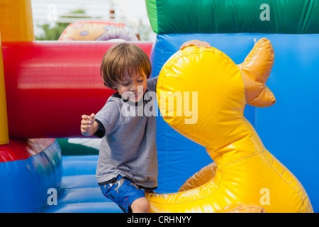 Ragazzo giocando in castello gonfiabile Foto Stock