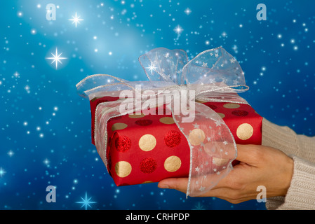 Donna di mani festively avvolto regalo di Natale Foto Stock