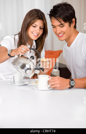 Coppia giovane avente la colazione a casa cercando felice Foto Stock