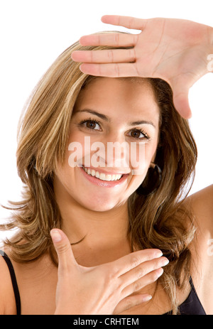 Giovani belle i capelli castani donna incorniciare il viso tra le mani Foto Stock