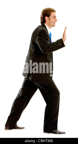 Business man spingendo qualcosa di immaginario Foto Stock