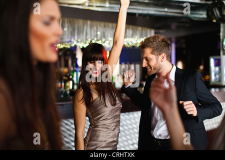 Sorridente amici Ballare in bar Foto Stock