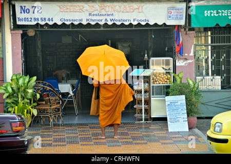 Munk Buddhistic elemosinando in piedi di fronte ad un ristorante (Binhabad), Cambogia, Phnom Penh Foto Stock