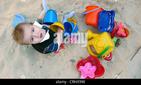 Little Boy giocando in una buca di sabbia Foto Stock