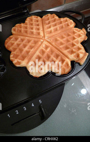 La fetta in una piastra per i waffle Foto Stock